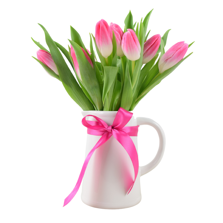 Fresh British grown pink tulips arranged in a white ceramic jug vase with a pink satin ribbon bow.